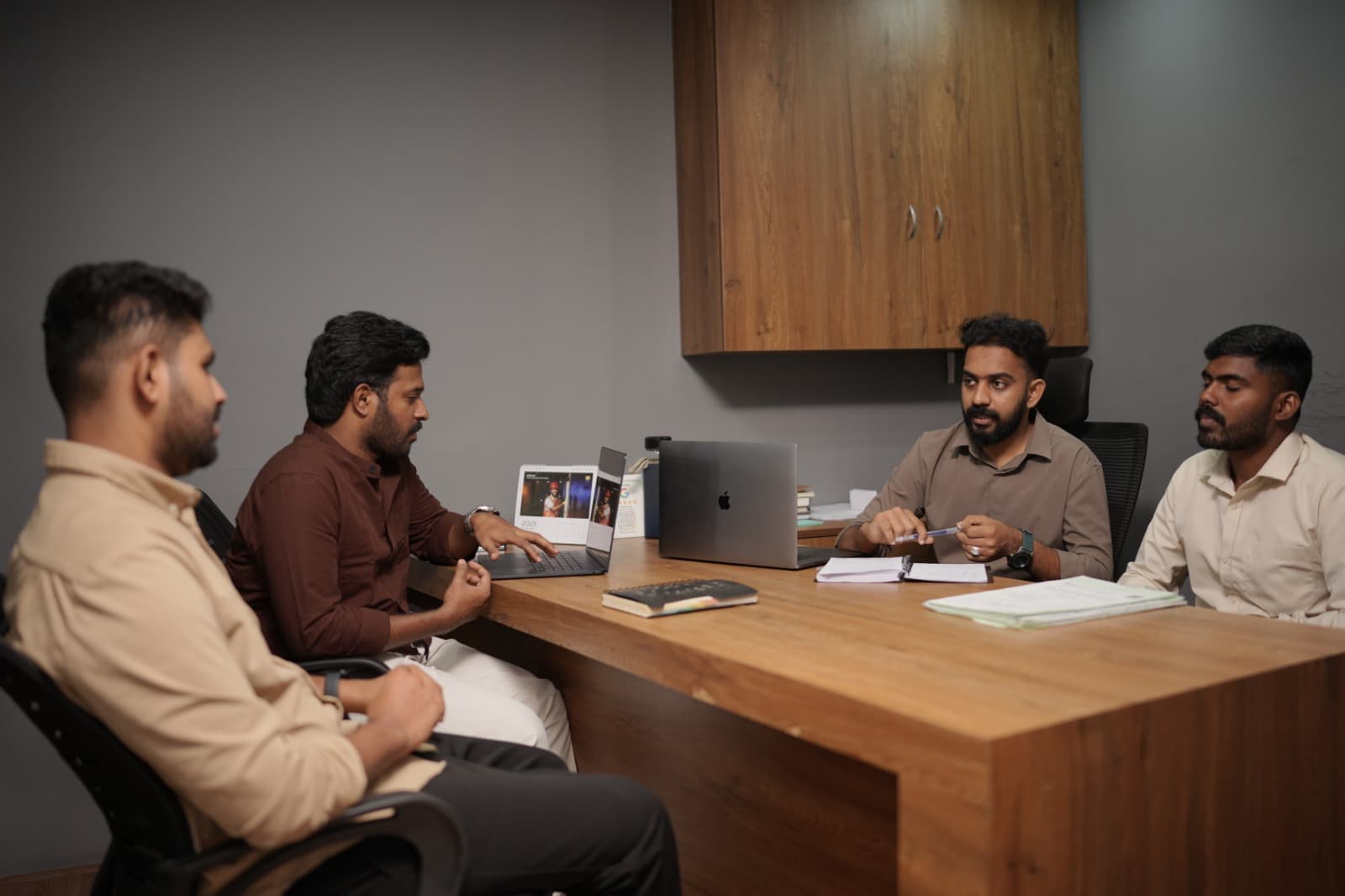 Pelago advisors in a client strategy meeting around a desk at HiLITE Business Park
